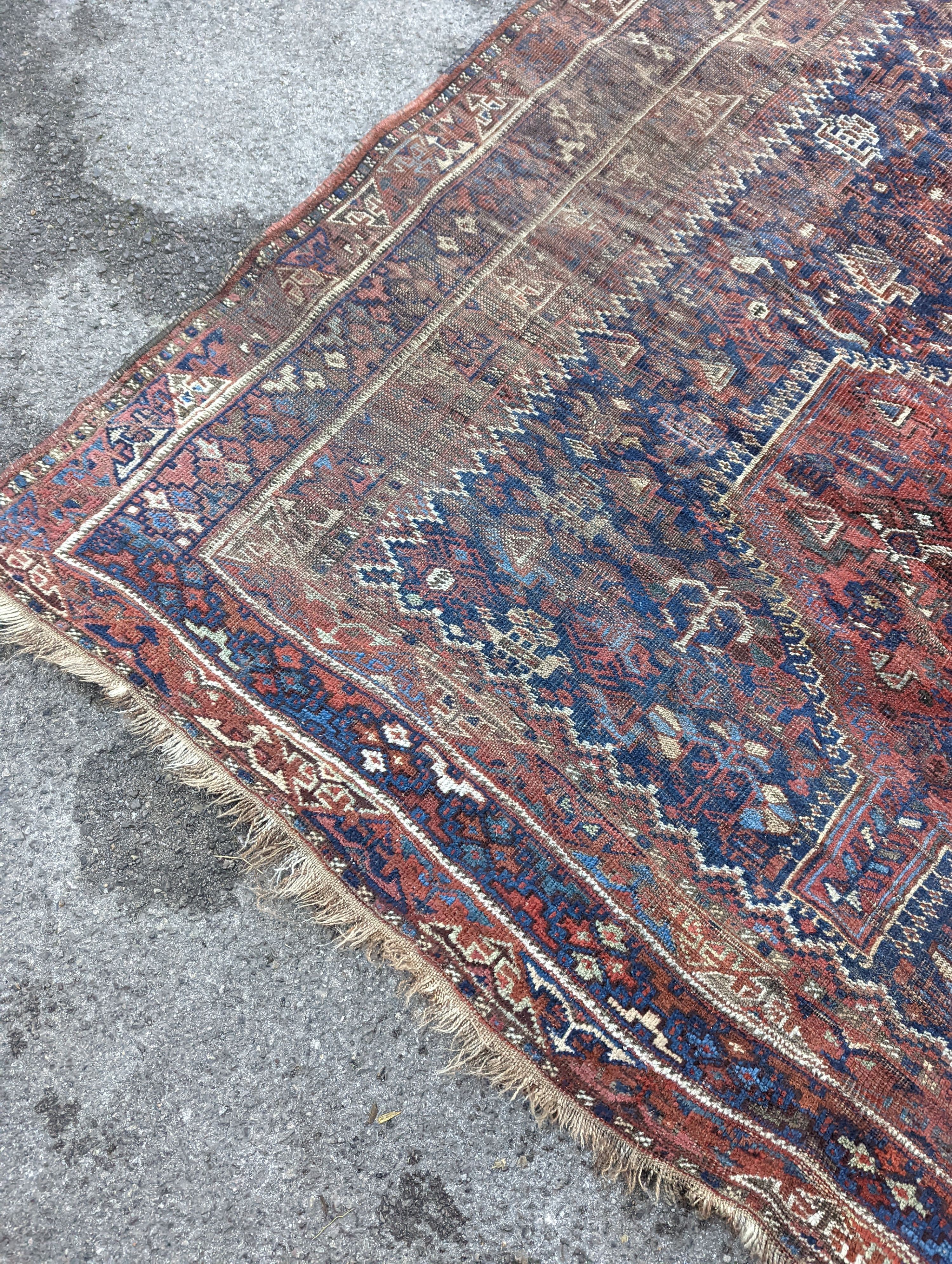 An antique Shirvan red ground carpet (worn), 295 x 207cm